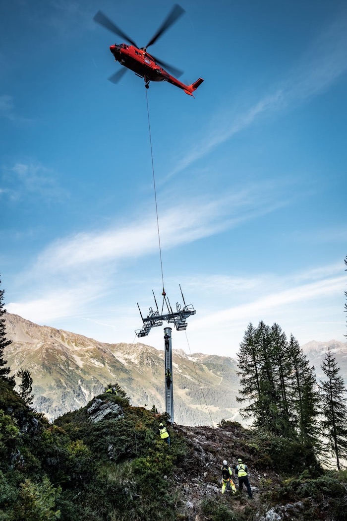 Helicopter delivering gantry to pylons on the new Arpettaz chairlift in Sainte Foy